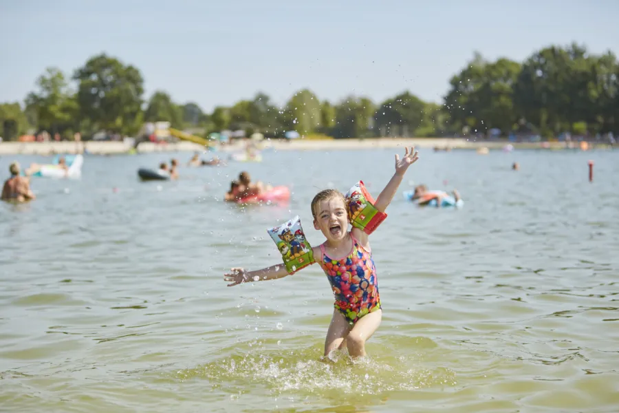 TerSpegelt zwemplas blij meisje in het water